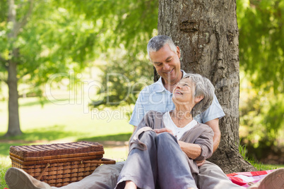 Senior man embracing woman from behind at park