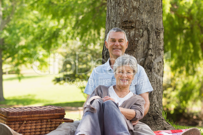 Senior man embracing woman from behind at park