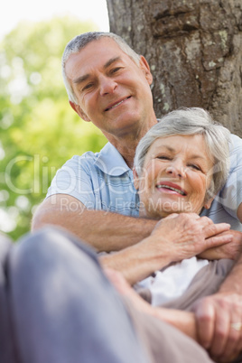 Senior man embracing woman from behind at park