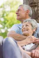 Senior man embracing woman from behind at park