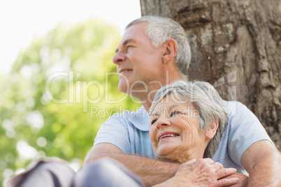 Senior man embracing woman from behind at park