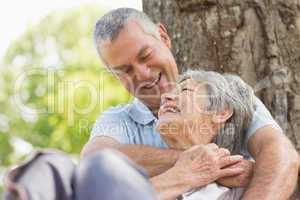 Senior man embracing woman from behind at park