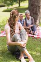 Woman with grandmother and granddaughter in background at park