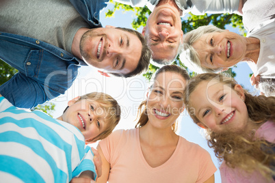 Extended family forming huddle in park