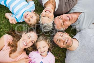 Extended family lying in circle at park