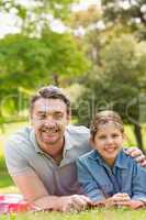 Father with young daughter lying on grass in park