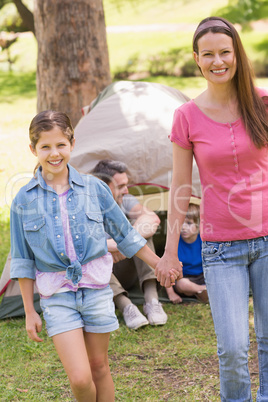 Mother and daughter with family behind in park