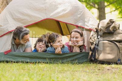 Couple with kids lying in the tent at park