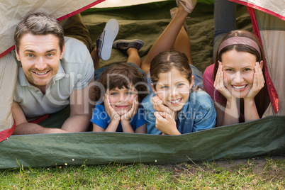 Couple with kids lying in the tent at park