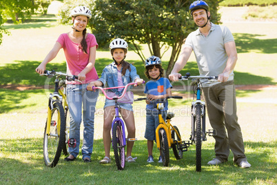 Family of four with bicycles in the park
