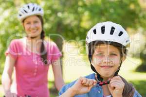 Smiling woman with her daughter riding bicycle
