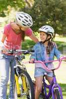 Smiling woman with her daughter riding bicycles