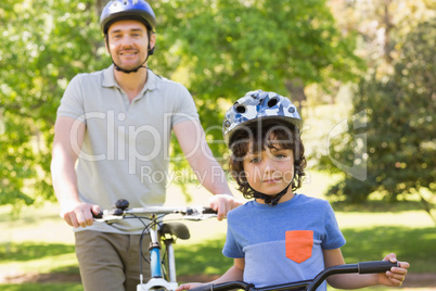 Smiling man with his son riding bicycles