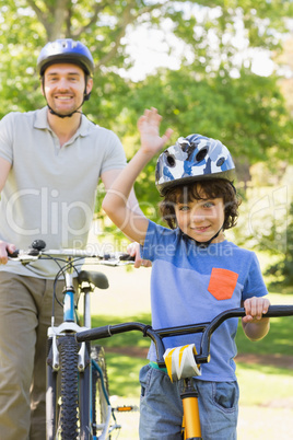 Smiling man with his son riding bicycles