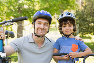 Smiling man with his son riding bicycles