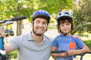 Smiling man with his son riding bicycles