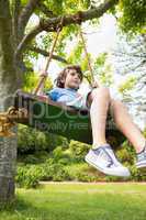 Low angle view of a cute little boy on swing