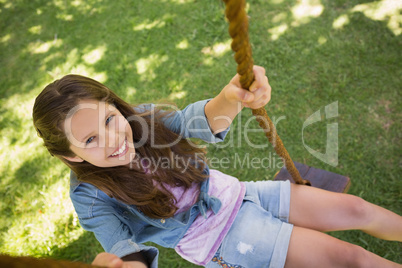 Cute little young girl sitting on swing