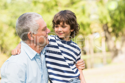 Grandfather and son smiling in the park