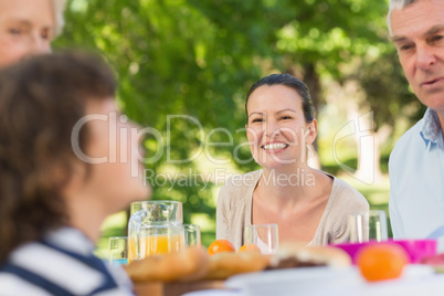 Woman sitting with family at outdoor dining table