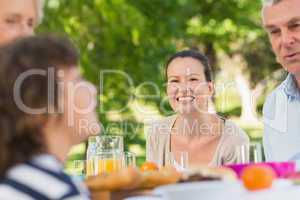 Woman sitting with family at outdoor dining table