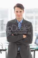 Handsome smiling businessman leaning on board room table