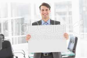 Handsome happy businessman holding placard