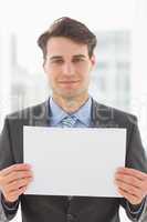 Smiling businessman holding blank page