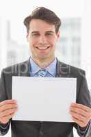 Happy businessman holding blank page
