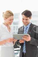 Smiling business team looking at tablet pc together