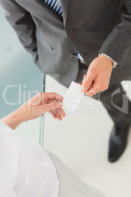 Businessman handing businesswoman his card