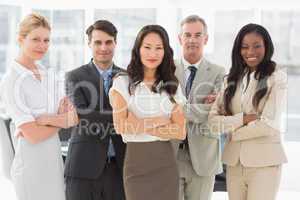 Business team smiling at camera with arms crossed