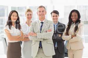 Business team smiling at camera with arms folded