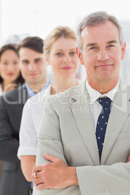 Business team standing in a line smiling at camera