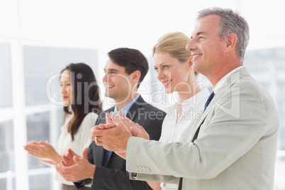 Business team standing in a line applauding