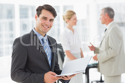 Businessman reading over a document smiling at camera