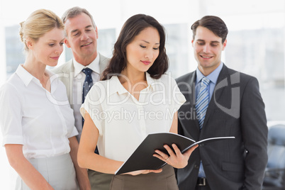 Businesswoman reading a document with her team