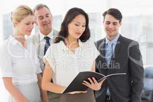 Businesswoman reading a document with her team