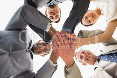 Business team looking down at the camera with hands together