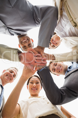 Happy business team looking down at the camera with hands togeth