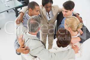 Diverse business team hugging in a circle