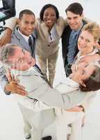 Diverse business team hugging in a circle smiling at camera