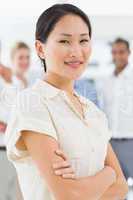 Pretty asian businesswoman standing with team behind her