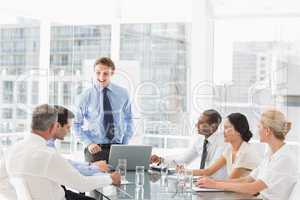 Businessman standing in front of his team at meeting