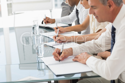 Business people taking notes at a meeting