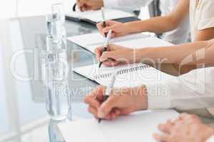 Business people taking down notes at a meeting