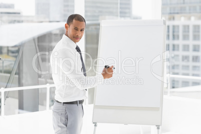 Young businessman presenting at whiteboard with marker