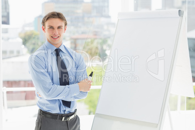 Young happy businessman standing by whiteboard