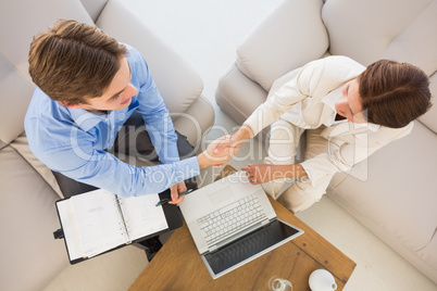 Business team working together on the couch shaking hands