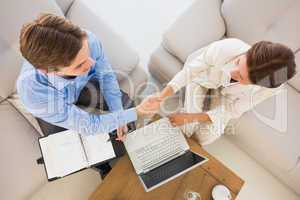 Business team working together on the couch shaking hands